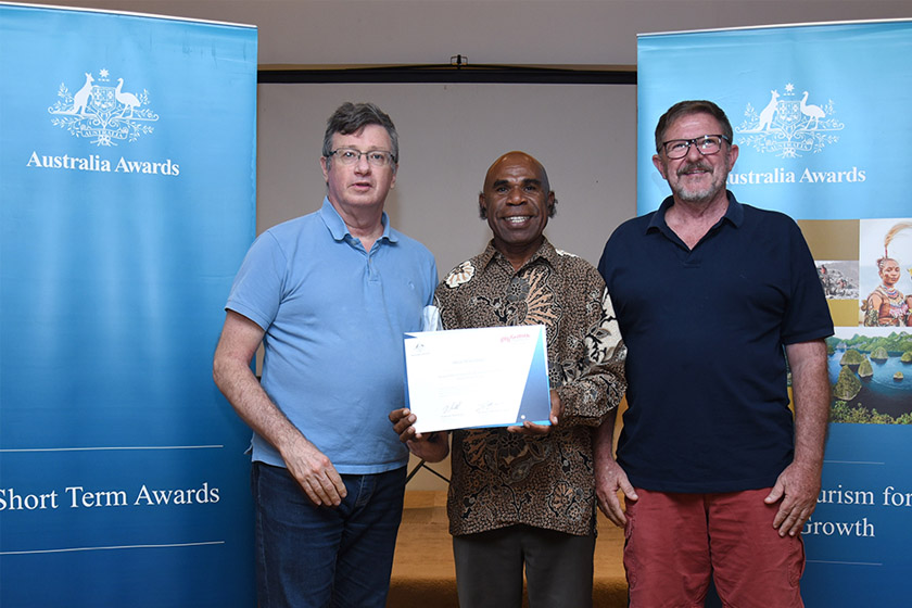 A group of multicultural men holding an award